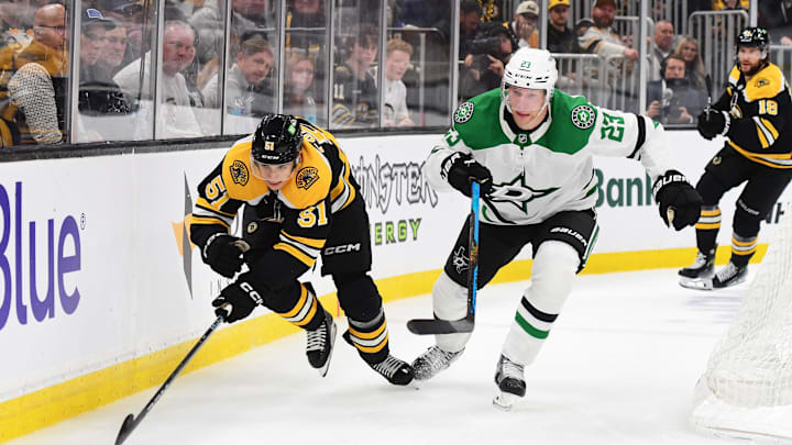 Oct 24, 2024; Boston, Massachusetts, USA;  Boston Bruins center Matthew Poitras (51) and Dallas Stars defenseman Esa Lindell (23) chase after the puck during the third period at TD Garden. Mandatory Credit: Bob DeChiara-Imagn Images