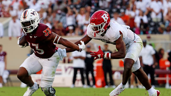 Sep 21, 2024; Blacksburg, Virginia, USA; Virginia Tech Hokies running back Bhayshul Tuten (33) runs the ball against Rutgers Scarlet Knights defensive back Desmond Igbinosun (4) during the fourth quarter at Lane Stadium. Mandatory Credit: Peter Casey-Imagn Images