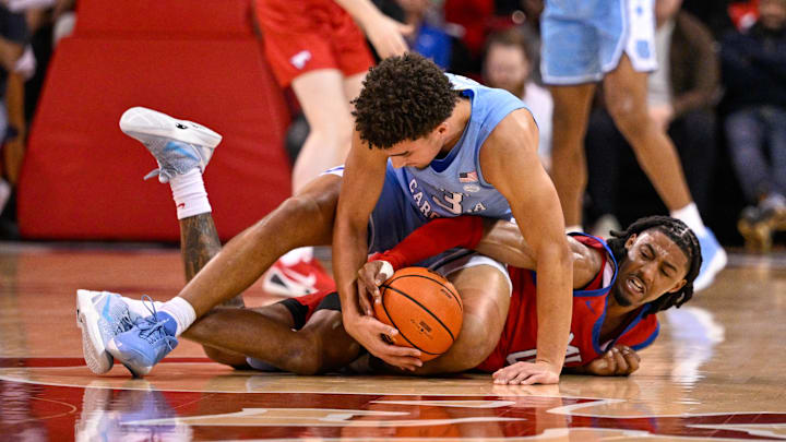 Jan 3, 2026; Dallas, Texas, USA; North Carolina Tar Heels guard Derek Dixon (3) and SMU Mustangs guard B.J. Edwards (0) battle for the loose ball during the second half at Moody Coliseum. Mandatory Credit: Jerome Miron-Imagn Images