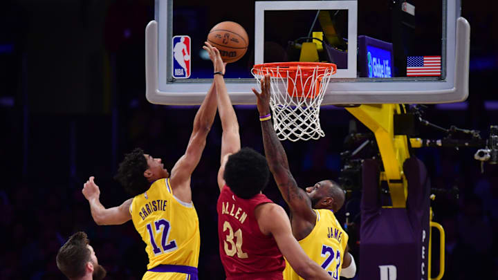 Dec 31, 2024; Los Angeles, California, USA;  Los Angeles Lakers guard Max Christie (12) and forward LeBron James (23) play for the rebound against Cleveland Cavaliers center Jarrett Allen (31) during the first half at Crypto.com Arena. Mandatory Credit: Gary A. Vasquez-Imagn Images