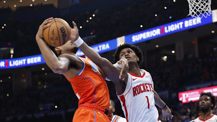 Nov 8, 2024; Oklahoma City, Oklahoma, USA;Houston Rockets forward Amen Thompson (1) reaches to steal the ball from Oklahoma City Thunder guard Ajay Mitchell (25)  during the second half at Paycom Center. Mandatory Credit: Alonzo Adams-Imagn Images