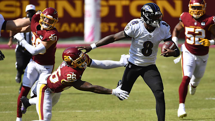 Oct 4, 2020; Landover, Maryland, USA; Baltimore Ravens quarterback Lamar Jackson (8) runs for a 50 yard touchdown against Washington Football Team strong safety Landon Collins (26) during the second quarter at FedExField. Mandatory Credit: Brad Mills-Imagn Images