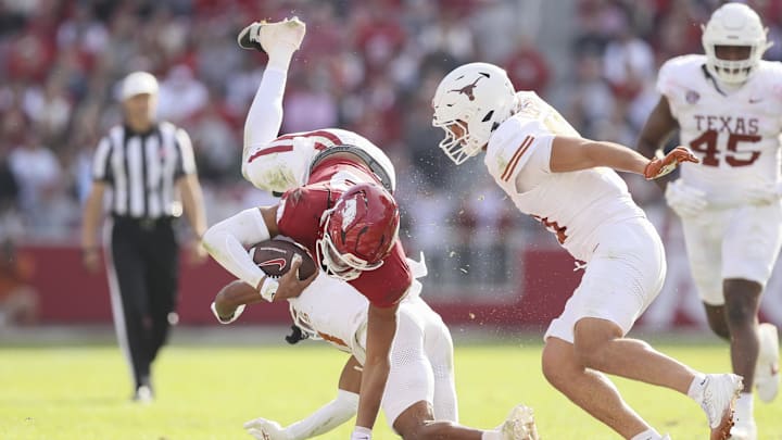 Nov 16, 2024; Fayetteville, Arkansas, USA; Arkansas Razorbacks quarterback Taylen Green (10) is tackled by Texas Longhorns defensive back Jaylon Guilbeau (3) as linebacker Liona Leaf (18) defends during the fourth quarter at Donald W. Reynolds Razorback Stadium. Texas won 20-10. Mandatory Credit: Nelson Chenault-Imagn Images