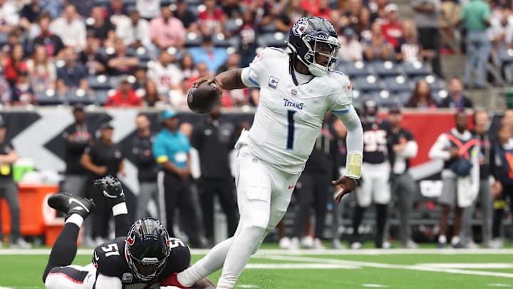 Sep 28, 2025; Houston, Texas, USA; Tennessee Titans quarterback Cam Ward (1) scrambles from Houston Texans defensive end Will Anderson Jr. (51) during the first half at NRG Stadium. Mandatory Credit: Troy Taormina-Imagn Images