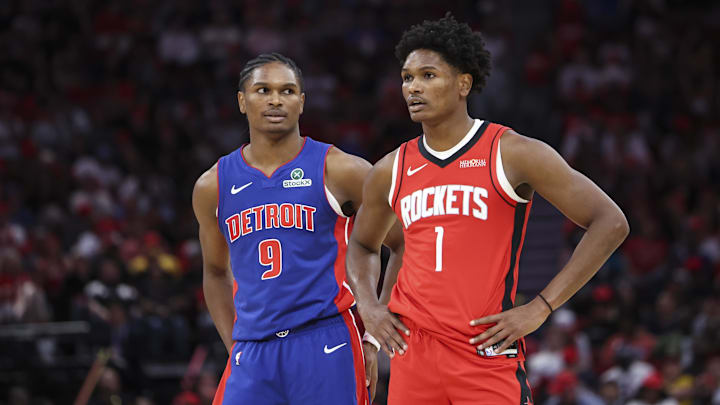 Oct 24, 2025; Houston, Texas, USA; Detroit Pistons guard Ausar Thompson (9) and twin brother Houston Rockets guard Amen Thompson (1) stand on the court during the third quarter at Toyota Center. Mandatory Credit: Troy Taormina-Imagn Images