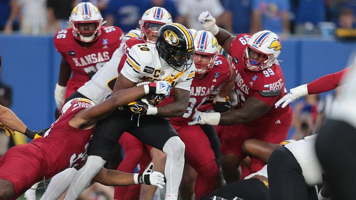 Missouri Tigers running back Jamal Roberts (20) is tackled by Kansas Jayhawks defensive end Leroy Harris III (33) during the game inside David Booth Kansas Memorial Stadium on Sept. 11, 2026. Missouri Tigers running back Jamal Roberts (20) is tackled by Kansas Jayhawks defensive end Leroy Harris III (33) during the game inside David Booth Kansas Memorial Stadium on Sept. 11, 2026.