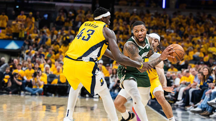 Apr 26, 2024; Indianapolis, Indiana, USA; Milwaukee Bucks guard Damian Lillard (0) looks to pass the ball while  Indiana Pacers forward Pascal Siakam (43) and guard Andrew Nembhard (2) defend during game three of the first round for the 2024 NBA playoffs at Gainbridge Fieldhouse. Mandatory Credit: Trevor Ruszkowski-Imagn Images