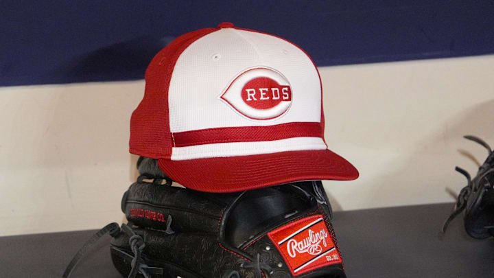 Apr 4, 2025; Milwaukee, Wisconsin, USA; Cincinnati Reds hat and glove rest on the bench in the dugout before a game against the Milwaukee Brewers at American Family Field. Mandatory Credit: Michael McLoone-Imagn Images Apr 4, 2025; Milwaukee, Wisconsin, USA; Cincinnati Reds hat and glove rest on the bench in the dugout before a game against the Milwaukee Brewers at American Family Field. Mandatory Credit: Michael McLoone-Imagn Images