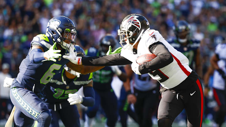 Sep 25, 2022; Seattle, Washington, USA; Atlanta Falcons wide receiver Drake London (5) breaks a tackle attempt by Seattle Seahawks safety Quandre Diggs (6) to score a touchdown on a reception during the third quarter at Lumen Field. Mandatory Credit: Joe Nicholson-Imagn Images