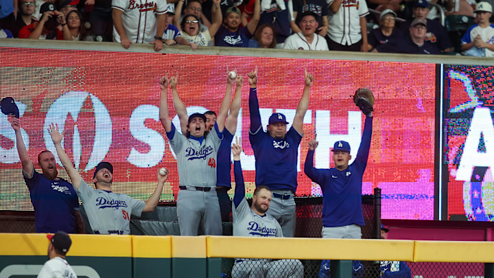 Sep 16, 2024; Atlanta, Georgia, USA; The Los Angeles Dodgers bullpen reacts after a home run hit by first baseman Freddie Freeman (not pictured) against the Atlanta Braves as left fielder Ramon Laureano (18) looks on in the seventh inning at Truist Park. Mandatory Credit: Brett Davis-Imagn Images Sep 16, 2024; Atlanta, Georgia, USA; The Los Angeles Dodgers bullpen reacts after a home run hit by first baseman Freddie Freeman (not pictured) against the Atlanta Braves as left fielder Ramon Laureano (18) looks on in the seventh inning at Truist Park. Mandatory Credit: Brett Davis-Imagn Images