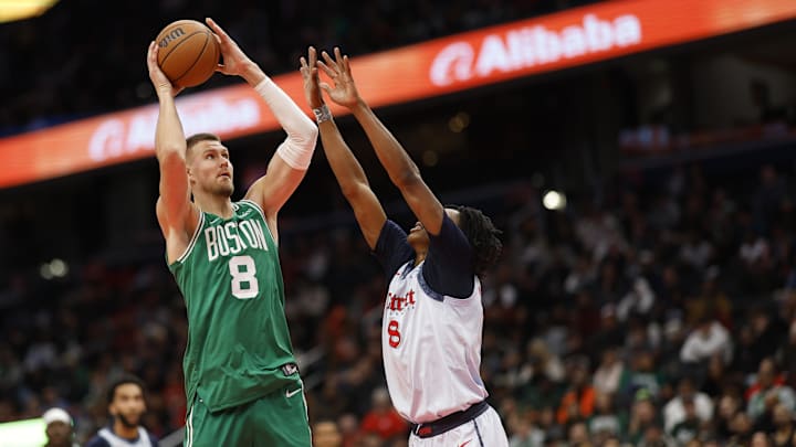 Dec 15, 2024; Washington, District of Columbia, USA; Boston Celtics center Kristaps Porzingis (8) shoots the ball as Washington Wizards guard Bub Carrington (8) defends in the second quarter at Capital One Arena. Mandatory Credit: Geoff Burke-Imagn Images