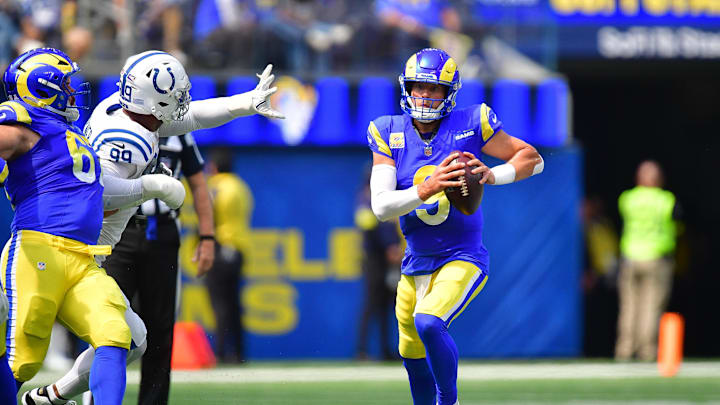 Sep 28, 2025; Inglewood, California, USA; Los Angeles Rams quarterback Matthew Stafford (9) runs the ball as Indianapolis Colts defensive tackle Deforest Buckner (99) moves in during the first half at SoFi Stadium. Mandatory Credit: Gary A. Vasquez-Imagn Images