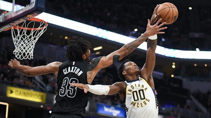 Mar 22, 2025; Indianapolis, Indiana, USA; Indiana Pacers guard Bennedict Mathurin (00) steals a pass from Brooklyn Nets center Nic Claxton (33) during the second half at Gainbridge Fieldhouse. Mandatory Credit: Robert Goddin-Imagn Images