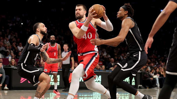 Mar 28, 2025; Brooklyn, New York, USA; Los Angeles Clippers center Ivica Zubac (40) drives to the basket against Brooklyn Nets guard Tyrese Martin (13) and center Nic Claxton (33) during the second quarter at Barclays Center. Mandatory Credit: Brad Penner-Imagn Images