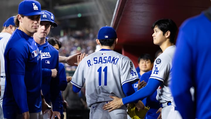 May 9, 2025; Phoenix, Arizona, USA; Los Angeles Dodgers pitcher Roki Sasaki (11) is greeted by Shohei Ohtani as he leaves the game in the fifth inning against the Arizona Diamondbacks at Chase Field. Mandatory Credit: Mark J. Rebilas-Imagn Images