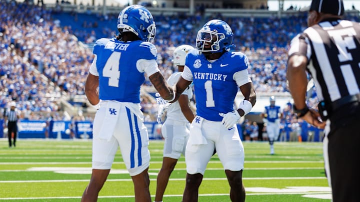 Aug 30, 2025; Lexington, Kentucky, USA; Kentucky Wildcats wide receiver Kendrick Law (1) celebrates with wide receiver J.J. Hester (4) after a play during the first quarter against the Toledo Rockets at Kroger Field. Mandatory Credit: Jordan Prather-Imagn Images
