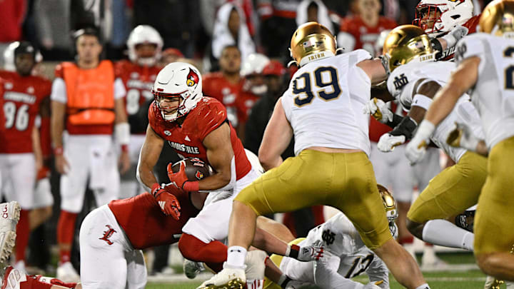 Oct 7, 2023; Louisville, Kentucky, USA; Louisville Cardinals running back Isaac Guerendo (23) runs the ball against Notre Dame Fighting Irish defensive lineman Rylie Mills (99) during the second half at L&N Federal Credit Union Stadium. Louisville defeated Notre Dame 33-20. Mandatory Credit: Jamie Rhodes-Imagn Images
