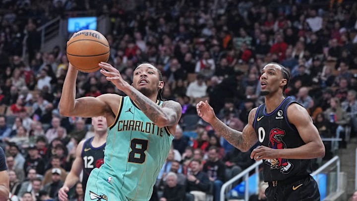 Apr 9, 2025; Toronto, Ontario, CAN; Charlotte Hornets guard Nick Smith Jr. (8) passes against Toronto Raptors guard A.J. Lawson (0) during the third quarter at Scotiabank Arena. Mandatory Credit: Nick Turchiaro-Imagn Images