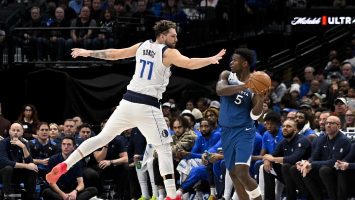 Jan 7, 2024; Dallas, Texas, USA; Dallas Mavericks guard Luka Doncic (77) attempts to knock the ball away from Minnesota Timberwolves guard Anthony Edwards (5)