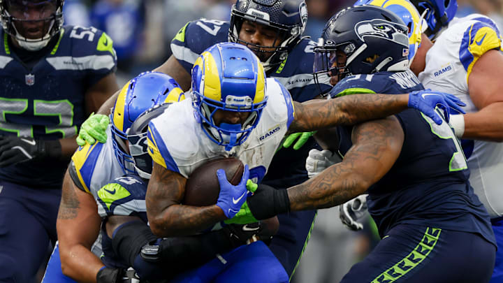 Nov 3, 2024; Seattle, Washington, USA; Los Angeles Rams running back Kyren Williams (23) rushes against Seattle Seahawks defensive tackle Byron Murphy II (91) and defensive tackle Johnathan Hankins (97) during the third quarter at Lumen Field. Mandatory Credit: Joe Nicholson-Imagn Images