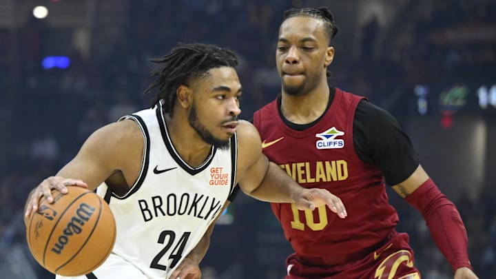 Mar 11, 2025; Cleveland, OH; Cam Thomas drives past Cavs guard Darius Garland at Rocket Arena. 