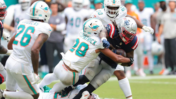 Sep 14, 2025; Miami Gardens, Florida, USA; New England Patriots running back Rhamondre Stevenson (38) carries the football against Miami Dolphins safety Minkah Fitzpatrick (29) during the fourth quarter at Hard Rock Stadium. Mandatory Credit: Sam Navarro-Imagn Images
