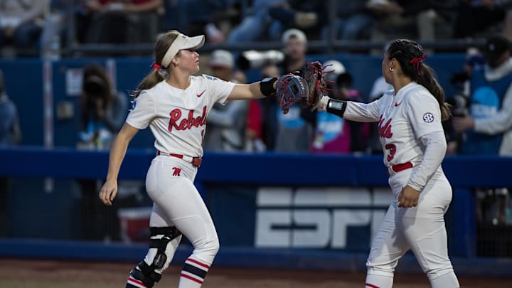 May 29, 2025; Oklahoma City, OK, USA; Ole Miss Rebels infielder Mackenzie Pickens (1) touches gloves with pitcher Persy Llamas (3) after the third out in the fifth inning against the Texas Tech Red Raiders during the NCAA Softball Women's College World Series at Devon Park. Mandatory Credit: Brett Rojo-Imagn Images