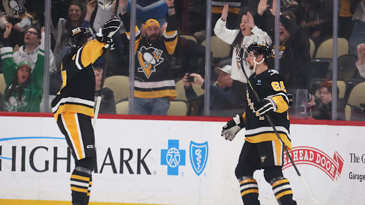 Mar 11, 2025; Pittsburgh, Pennsylvania, USA;  Pittsburgh Penguins right wing Rickard Rakell (left) and defenseman Erik Karlsson (65) celebrate the game winning goal by Karlsson to defeat the Vegas Golden Knights in overtime at PPG Paints Arena. Mandatory Credit: Charles LeClaire-Imagn Images