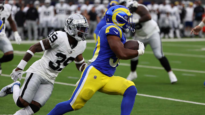 Aug 19, 2023; Inglewood, California, USA;  Los Angeles Rams running back Ronnie Rivers (30) runs with a ball against Las Vegas Raiders cornerback Nate Hobbs (39) during the first quarter at SoFi Stadium. Mandatory Credit: Kiyoshi Mio-Imagn Images