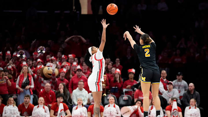 Michigan Wolverines guard Macy Brown (2) hits a three pointer over Ohio State Buckeyes guard Chance Gray (2) during overtime of the NCAA women's basketball game at the Jerome Schottenstein Center on Feb. 25, 2026. Ohio State lost 88-86 in overtime.