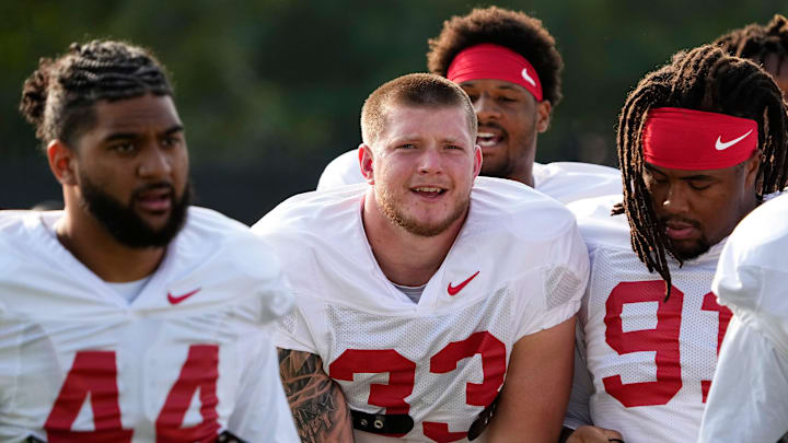 Aug 8, 2024; Columbus, Ohio, USA; Ohio State Buckeyes defensive ends JT Tuimoloau (44), Jack Sawyer (33) and defensive tackle Tyleik Williams (91) huddle together during football practice at the Woody Hayes Athletic Complex.