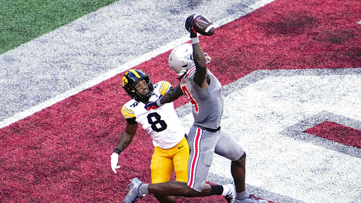 Oct 5, 2024; Columbus, Ohio, USA; Ohio State Buckeyes wide receiver Jeremiah Smith (4) makes a one-handed touchdown catch against Iowa Hawkeyes defensive back Deshaun Lee (8) in the third quarter at Ohio Stadium. Mandatory Credit: Samantha Madar/USA TODAY Network via Imagn Images