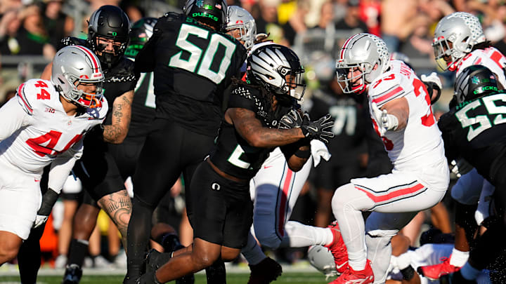 Oct 12, 2024; Eugene, Oregon, USA; Ohio State Buckeyes defensive end JT Tuimoloau (44) and defensive end Jack Sawyer (33) try to tackle Oregon Ducks running back Jordan James (20) during the first half of the NCAA football game at Autzen Stadium