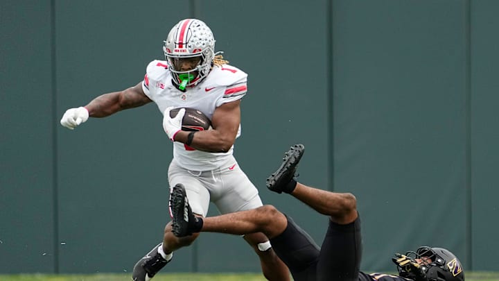 Ohio State Buckeyes running back Quinshon Judkins (1) runs over Northwestern Wildcats defensive back Damon Walters (21) during the NCAA football game at Wrigley Field in Chicago on Monday, Nov. 18, 2024. Ohio State won 31-7.