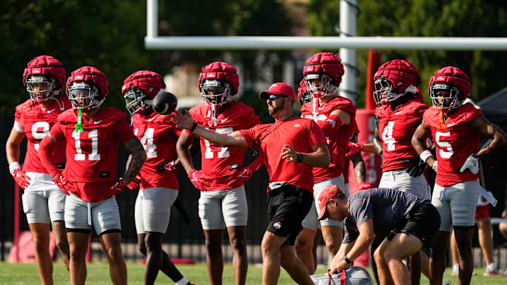 Aug 1, 2024; Columbus, OH, USA; Ohio State Buckeyes co-offensive coordinator Brian Hartline throws passes to his wide receivers during football camp at the Woody Hayes Athletic Complex.