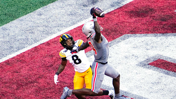 Oct 5, 2024; Columbus, Ohio, USA; Ohio State Buckeyes wide receiver Jeremiah Smith (4) makes a one-handed touchdown catch against Iowa Hawkeyes defensive back Deshaun Lee (8) in the third quarter at Ohio Stadium on Saturday.