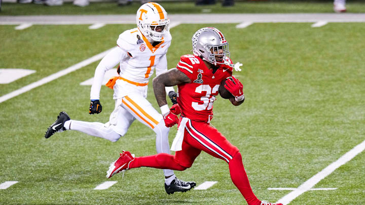 Ohio State Buckeyes running back TreVeyon Henderson (32) runs the ball against Tennessee Volunteers defensive back Rickey Gibson III (1) in the second half at Ohio Stadium on Saturday, Dec. 21, 2024 in Columbus, Ohio.