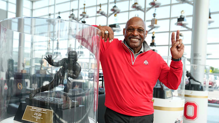 Jul 16, 2024; Columbus, OH, USA; Former Ohio State running back Archie Griffin stands with his two Heisman trophies inside the Woody Hayes Athletic Center. Griffin, who won the award in 1974 and 1975, is still the only two-time Heisman winner.