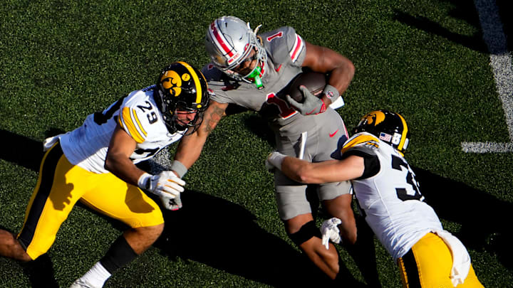 Oct 5, 2024; Columbus, Ohio, USA; Ohio State Buckeyes running back Quinshon Judkins (1) is tackled by Iowa Hawkeyes defensive back Deavin Hilson (20) and defensive back Sebastian Castro (29) in the second quarter at Ohio Stadium on Saturday.