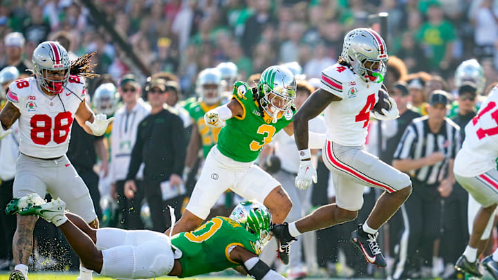 Ohio State Buckeyes wide receiver Jeremiah Smith (4) leaps past Oregon Ducks defensive back Tysheem Johnson (0) on his way to scoring a touchdown during the College Football Playoff quarterfinal at the Rose Bowl in Pasadena, Calif. on Jan. 1, 2025. Ohio State won 41-21.