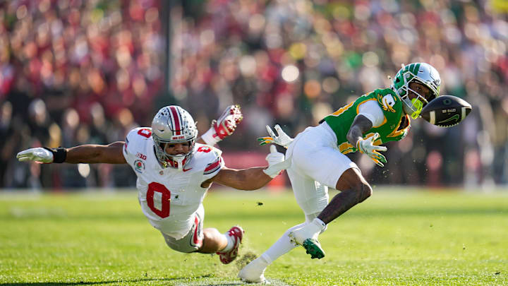 Oregon Ducks wide receiver Tez Johnson (15) bobbles but catches a pass in front of Ohio State Buckeyes linebacker Cody Simon (0) during the first half of the College Football Playoff quarterfinal at the Rose Bowl in Pasadena, Calif. on Jan. 1, 2025.