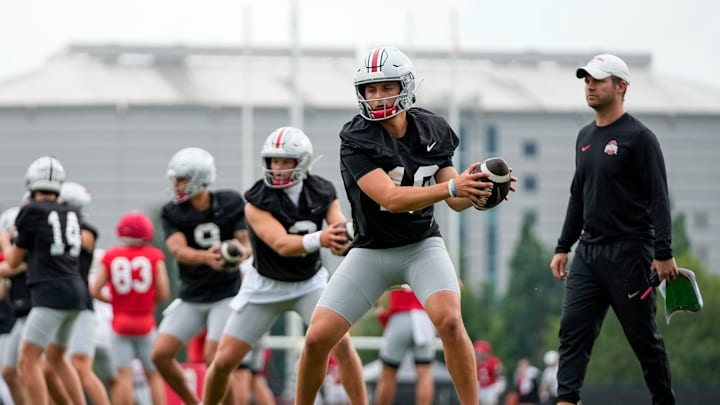 Ohio State Buckeyes quarterback Julian Sayin (10) takes a snap in front of quarterbacks coach Billy Fessler during the first football practice of the season at the Woody Hayes Athletic Center on July 31, 2025.