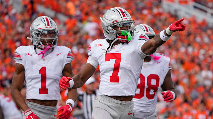 Ohio State Buckeyes cornerback Jermaine Mathews Jr. (7), cornerback Davison Igbinosun (1) and defensive lineman Kayden McDonald (98) celebrate after a fumble by Illinois Fighting Illini quarterback Luke Altmyer (9) during the second half of the NCAA football game at Gies Memorial Stadium in Champaign on Oct. 11, 2025. Ohio State won 34-16.