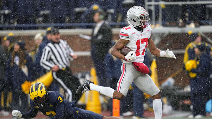 Ohio State Buckeyes wide receiver Carnell Tate (17) scores a touchdown over Michigan Wolverines defensive back Jaden Mangham (3) during the NCAA football game at Michigan Stadium in Ann Arbor, Mich. on Nov. 29, 2025. Ohio State won 27-9.