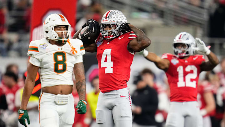 Ohio State Buckeyes wide receiver Jeremiah Smith (4) celebrates a first down beside Miami Hurricanes defensive back Jakobe Thomas (8) during the Cotton Bowl at AT&T Stadium in Arlington, Texas for the College Football Playoff quarterfinal game on Dec. 31, 2025. Ohio State lost 24-14.