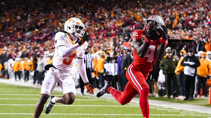 Dec 21, 2024; Columbus, Ohio, USA; Ohio State Buckeyes wide receiver Jeremiah Smith (4) catches a touchdown pass against Tennessee Volunteers defensive back Jermod McCoy (3) in the second half at Ohio Stadium. Mandatory Credit: Samantha Madar/USA Today Network via Imagn Images