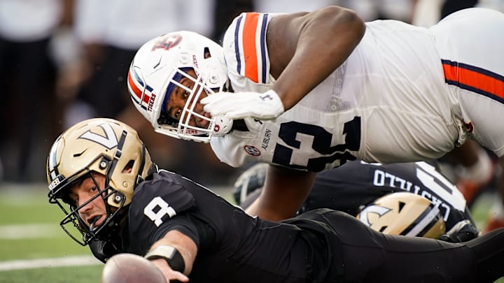 Vanderbilt quarterback Ken Seals (8) and Auburn defensive lineman Justin Rogers (52) dive after a