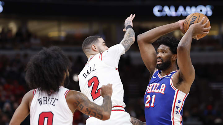 Dec 8, 2024; Chicago, Illinois, USA; Philadelphia 76ers center Joel Embiid (21) looks to pass the ball against Chicago Bulls guard Lonzo Ball (2) during the second half at United Center. Mandatory Credit: Kamil Krzaczynski-Imagn Images