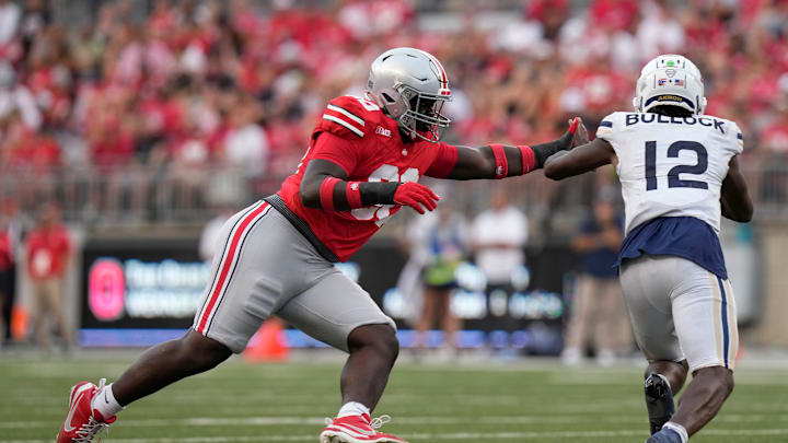 Aug 31, 2024; Columbus, OH, USA; Ohio State Buckeyes defensive lineman Eric Mensah (90) pursues Akron Zips quarterback Tahj Bullock (12) during the second half of the NCAA football game at Ohio Stadium. Ohio State won 52-6.