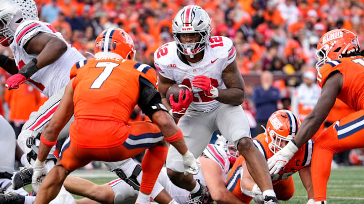 Ohio State Buckeyes running back CJ Donaldson Jr. (12) runs toward Illinois Fighting Illini defensive back Matthew Bailey (7) during the second half of the NCAA football game at Gies Memorial Stadium in Champaign on Oct. 11, 2025. Ohio State won 34-16.